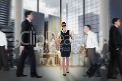 Composite image of redhead businesswoman in a blindfold