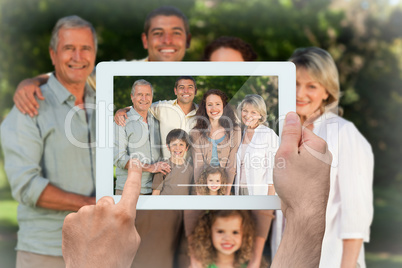 Composite image of hand holding tablet pc