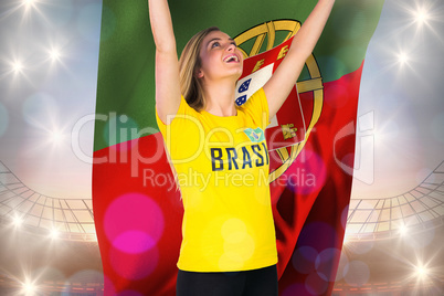 Excited football fan in brasil tshirt holding portugal flag