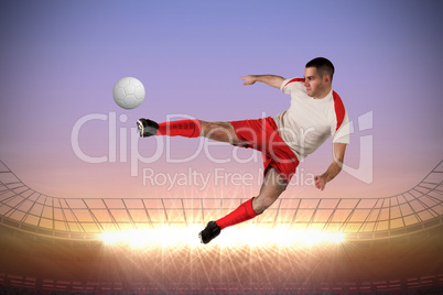 Fit football player playing and kicking