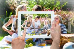 Composite image of hand holding tablet pc