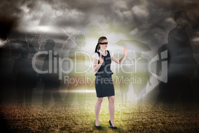 Composite image of redhead businesswoman in a blindfold