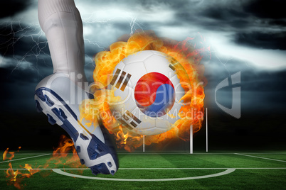 Football player kicking flaming south korea flag ball