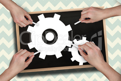 Composite image of multiple hands drawing cogs with chalk