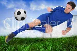 Football player in blue kicking the ball