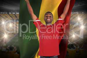 Excited handsome football fan cheering holding ghana flag