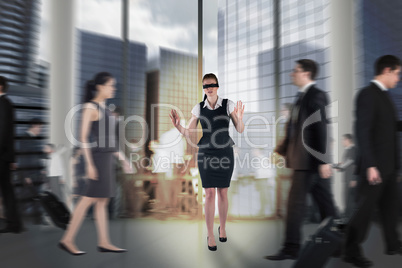 Composite image of redhead businesswoman in a blindfold