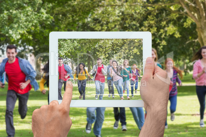 Composite image of hand holding tablet pc