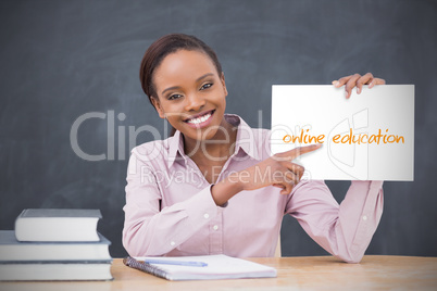 Happy teacher holding page showing online education