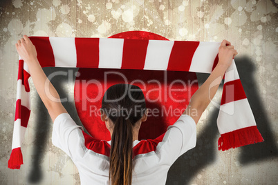 Football fan waving red and white scarf