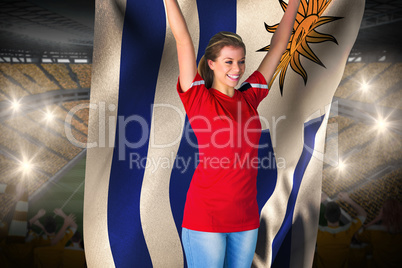 Cheering football fan in red holding uruguay flag