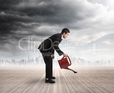 Composite image of businessman watering with red can