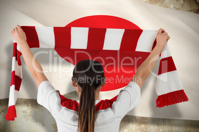 Football fan waving red and white scarf