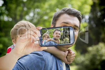 Composite image of hand holding smartphone showing