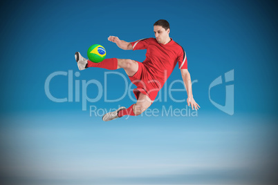 Fit football player jumping and kicking