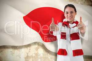 Football fan in white wearing scarf showing thumbs up