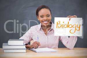 Happy teacher holding page showing biology