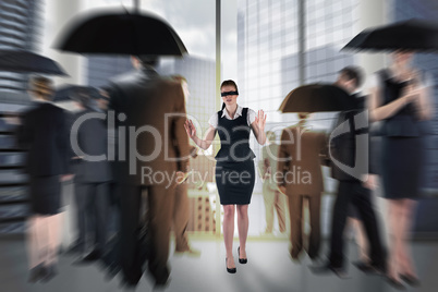 Composite image of redhead businesswoman in a blindfold