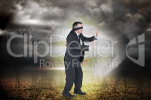 Composite image of mature businessman in a blindfold