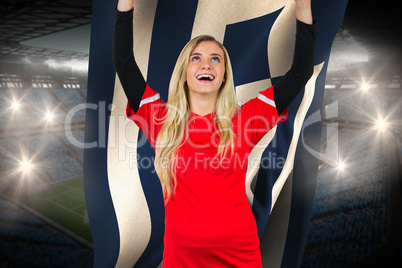 Cheering football fan in red holding greece flag