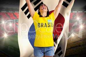Excited football fan in brasil tshirt holding south korea flag