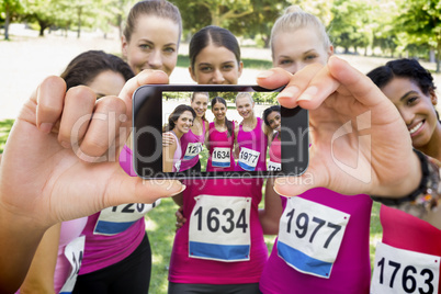 Composite image of hand holding smartphone showing