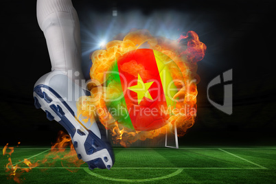 Football player kicking flaming cameroon flag ball