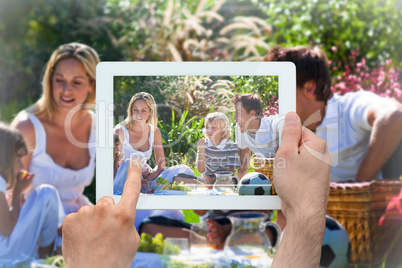 Composite image of hand holding tablet pc