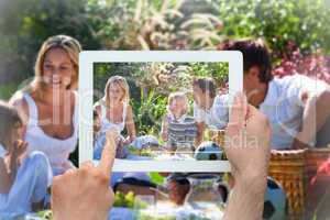 Composite image of hand holding tablet pc