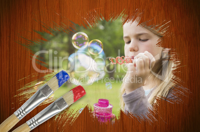Composite image of little girl blowing bubbles