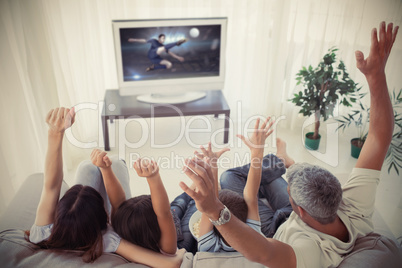 Family cheering and watching the world cup at home