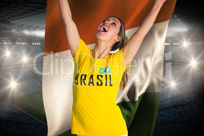 Pretty football fan in brasil t-shirt holding ivory coast flag