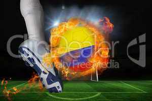 Football player kicking flaming colombia flag ball