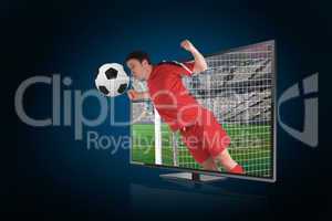 Football player in red heading ball through tv