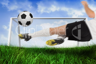 Football player in white kicking the ball