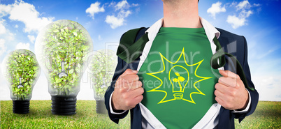 Composite image of businessman opening shirt in superhero style