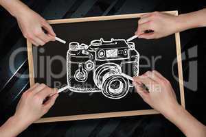 Composite image of multiple hands drawing camera with chalk
