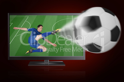 Football player in blue kicking ball out of tv