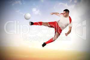 Fit football player playing and kicking