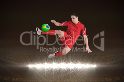 Fit football player jumping and kicking