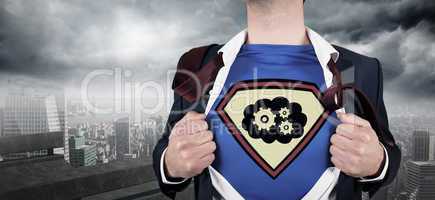 Composite image of businessman opening shirt in superhero style