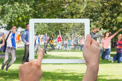 Composite image of hand holding tablet pc