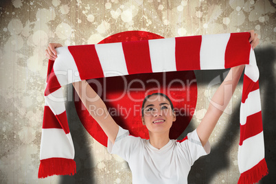 Football fan waving red and white scarf