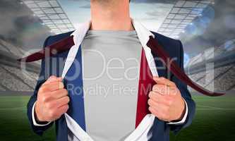 Businessman opening shirt to reveal france flag