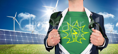 Composite image of businessman opening shirt in superhero style