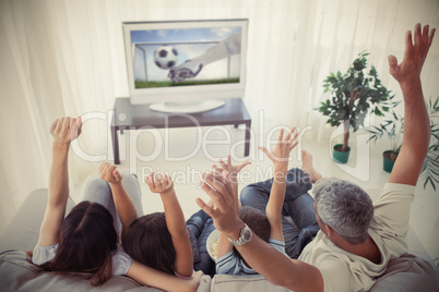 Family cheering and watching the world cup at home