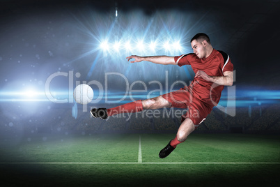 Fit football player playing and kicking