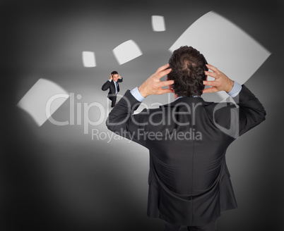 Composite image of stressed businessman with tiny businessman