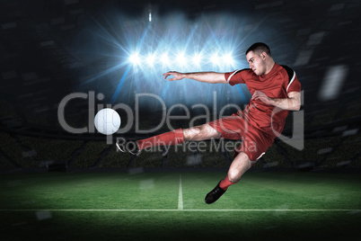 Fit football player playing and kicking