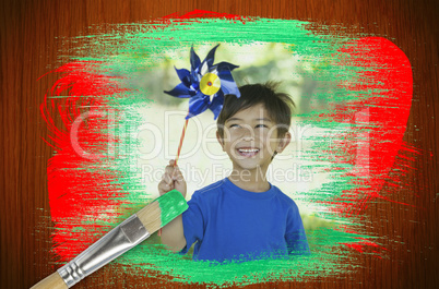 Composite image of little boy with pinwheel